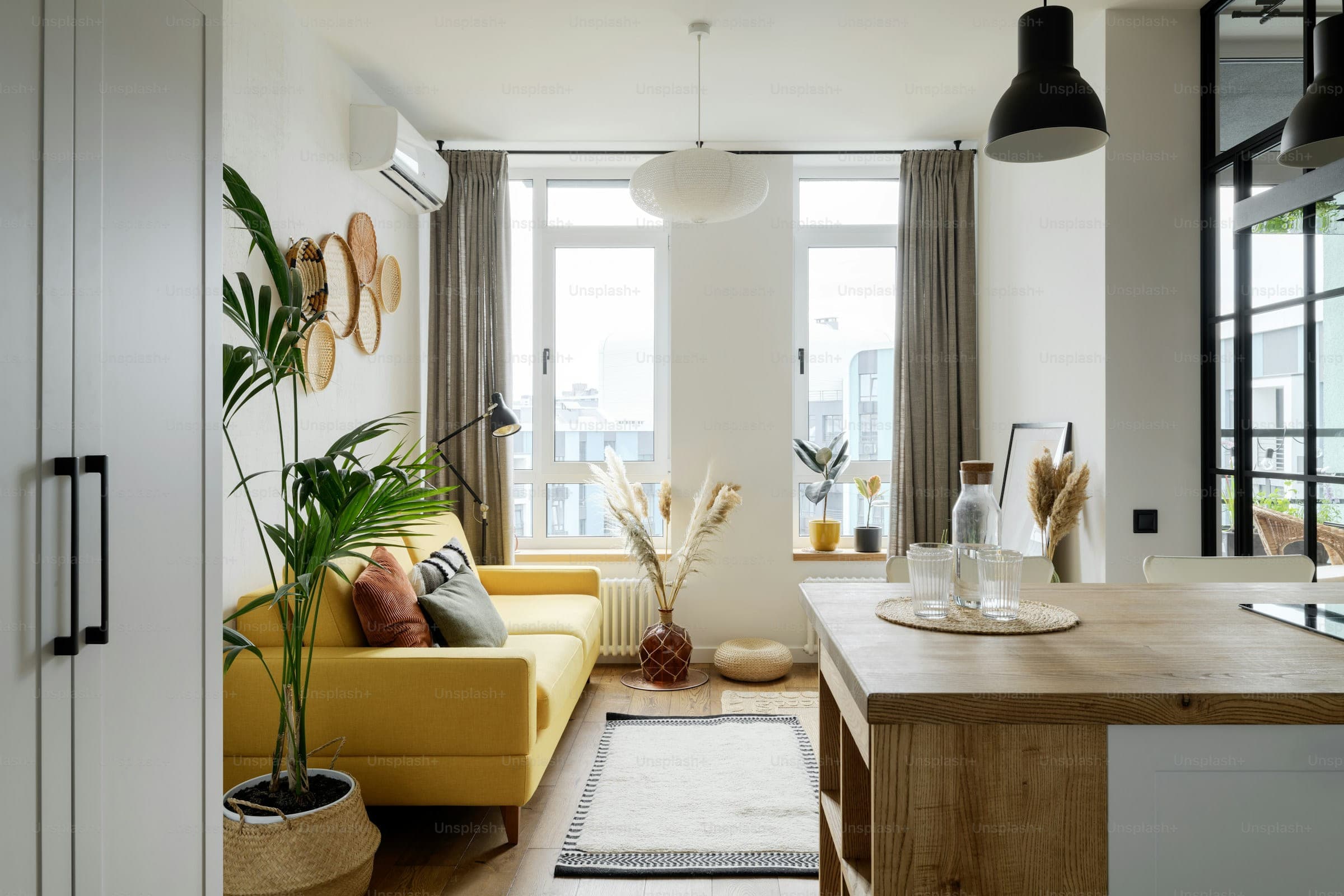 Compact apartment living room with a yellow sofa beside a large window